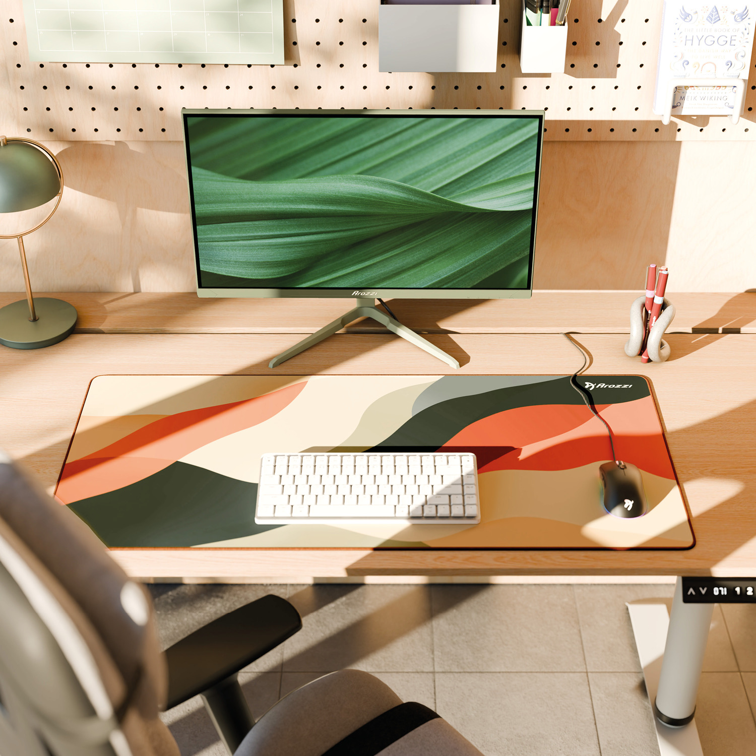 Ein Schreibtisch mit Monitor, Tastatur, Maus und einer bunten Unterlage.