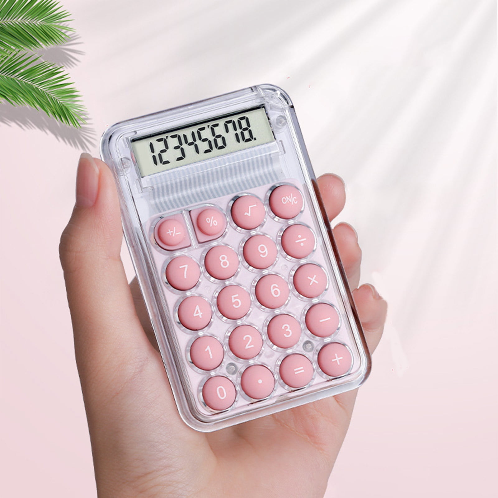 Eine Hand hält einen transparenten, rosafarbenen Taschenrechner mit Zahlen und Symbolen.