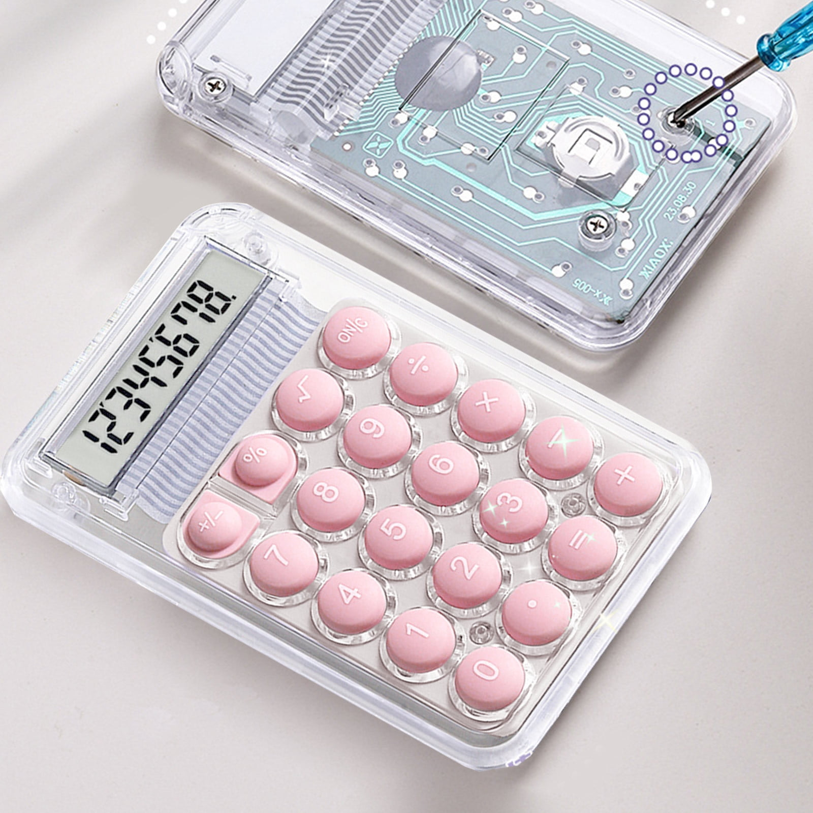 Transparenter Taschenrechner mit rosa Tasten und LCD-Display. Leiterplatte sichtbar.