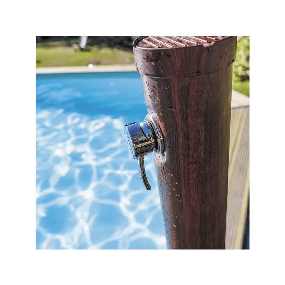 Ducha de madera con grifo cromado junto a una piscina de agua azul.