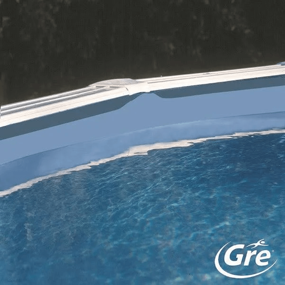 Primer plano del borde de una piscina azul con agua ondulada y fondo oscuro.