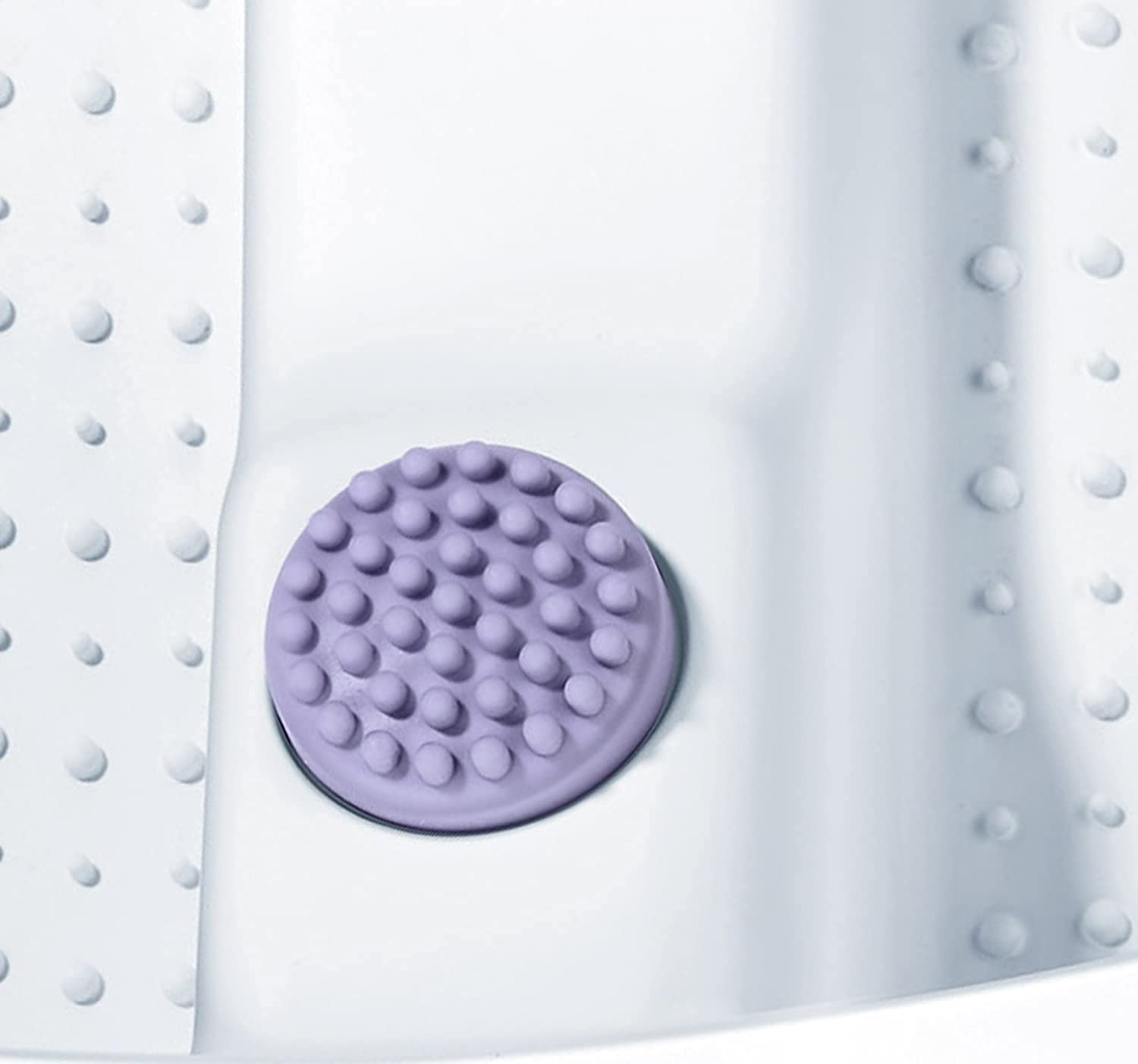 Purple round textured mat with small bumps on a white surface.