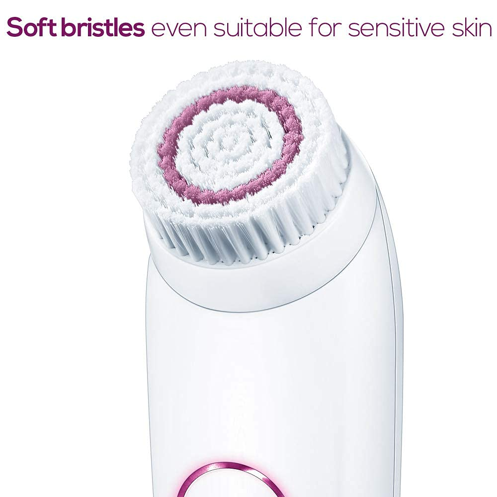 Close-up of a white facial cleansing brush with soft bristles and a pink inner ring.