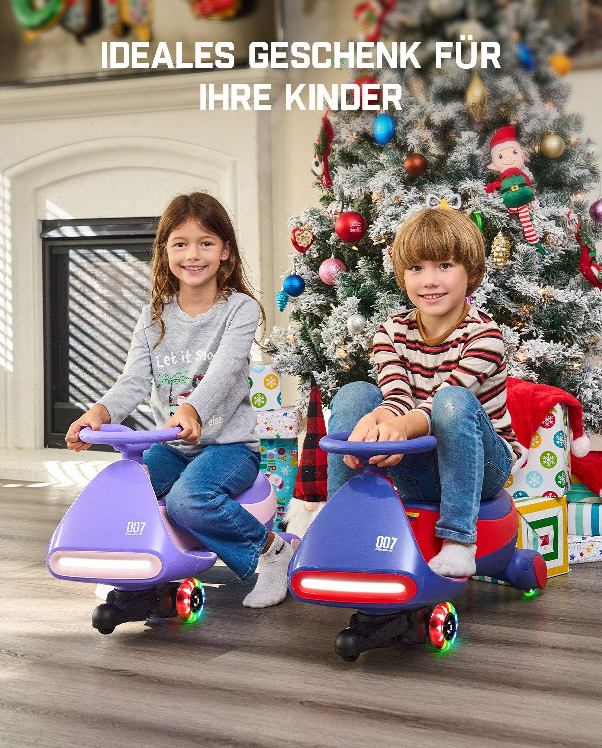 Zwei Kinder sitzen auf bunten Spielzeugautos vor einem Weihnachtsbaum mit Geschenken.