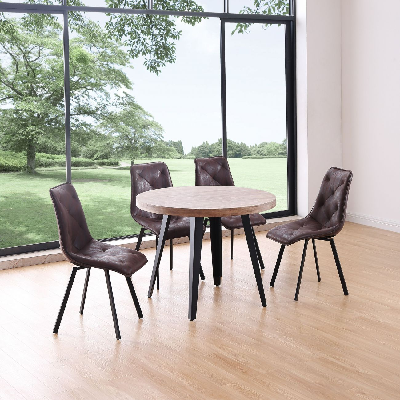 Una mesa redonda de madera con cuatro sillas de cuero marrón frente a una ventana grande.