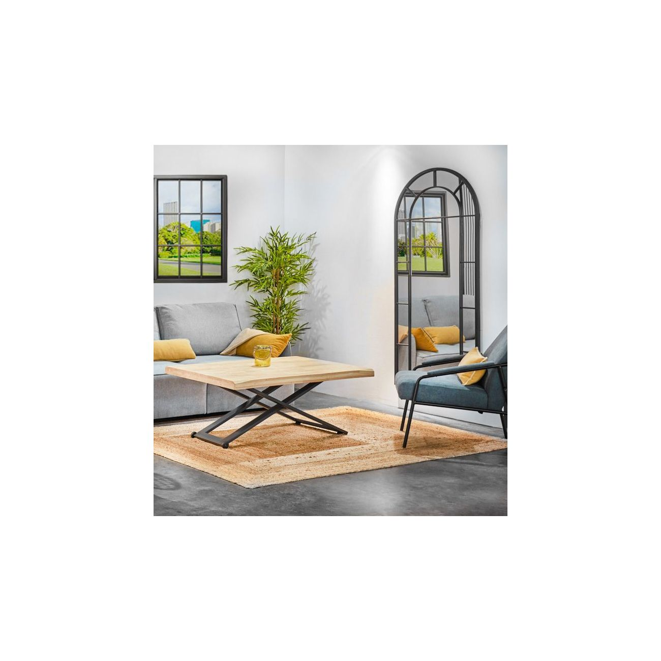 Una sala de estar con sofá, mesa de centro, sillón, espejo y planta.