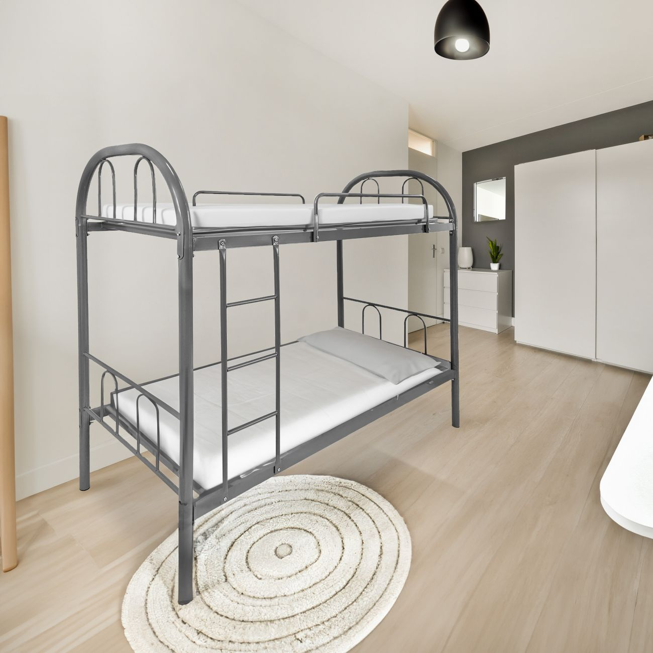 Una litera de metal gris con colchones blancos sobre suelo de madera.