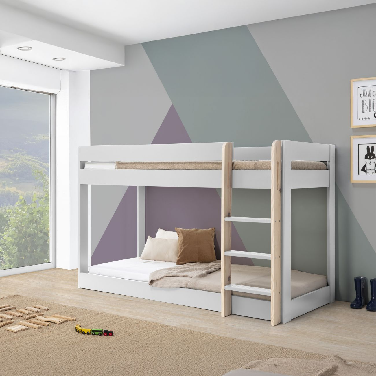 Litera blanca con escalera de madera, cojines, mantas y juguetes en habitación infantil.
