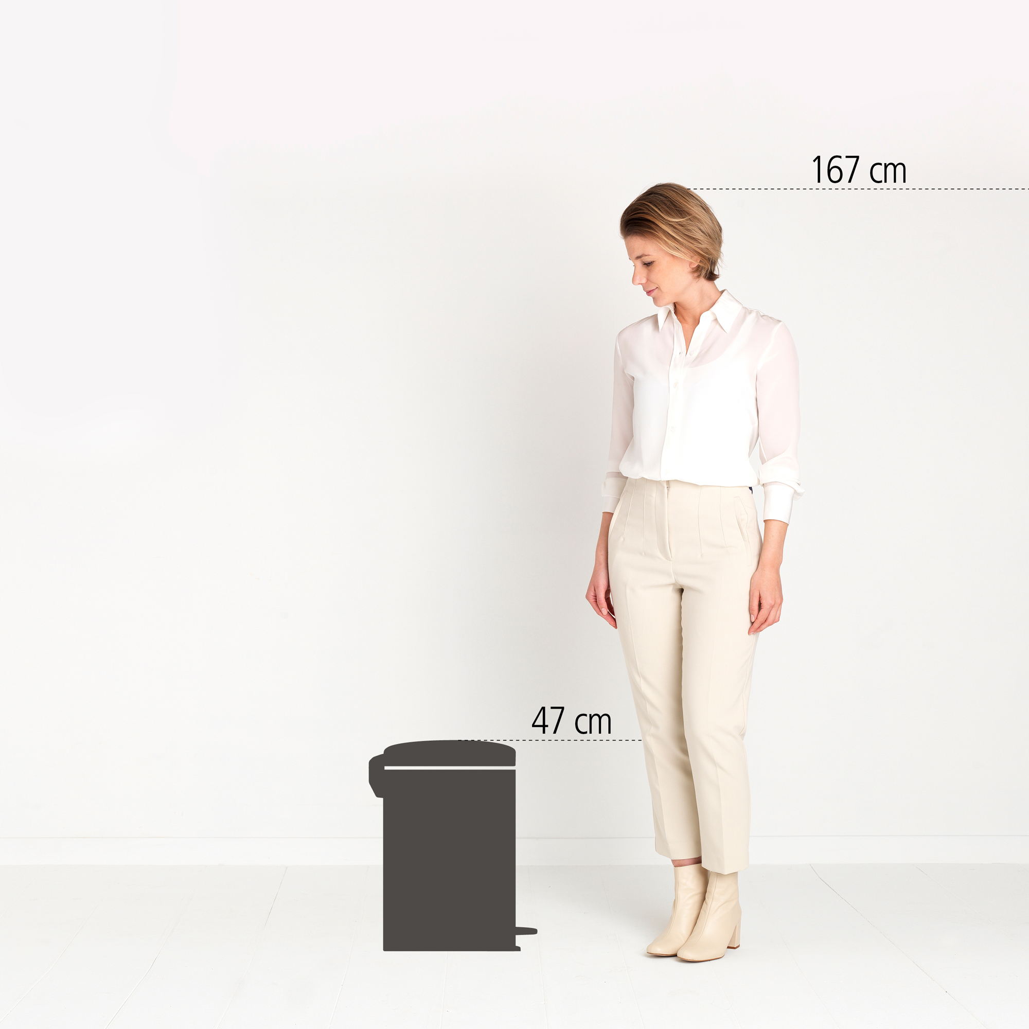 Een vrouw staat naast een prullenbak met pedaal. Haar lengte is 167 cm, die van de bak 47 cm.