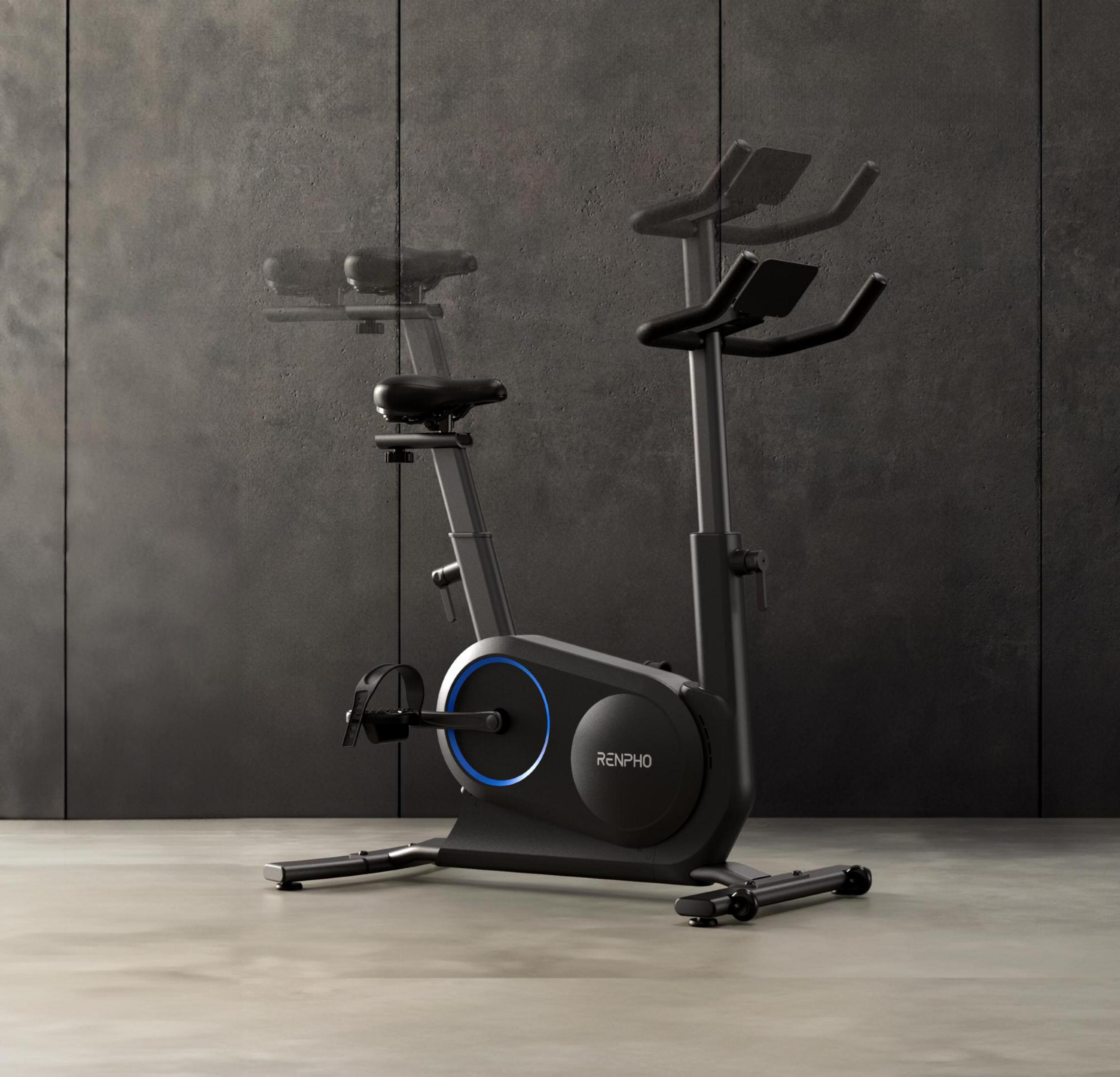 Ein schwarzes Heimtrainer-Fahrrad mit blauem Lichtring steht auf Betonboden.