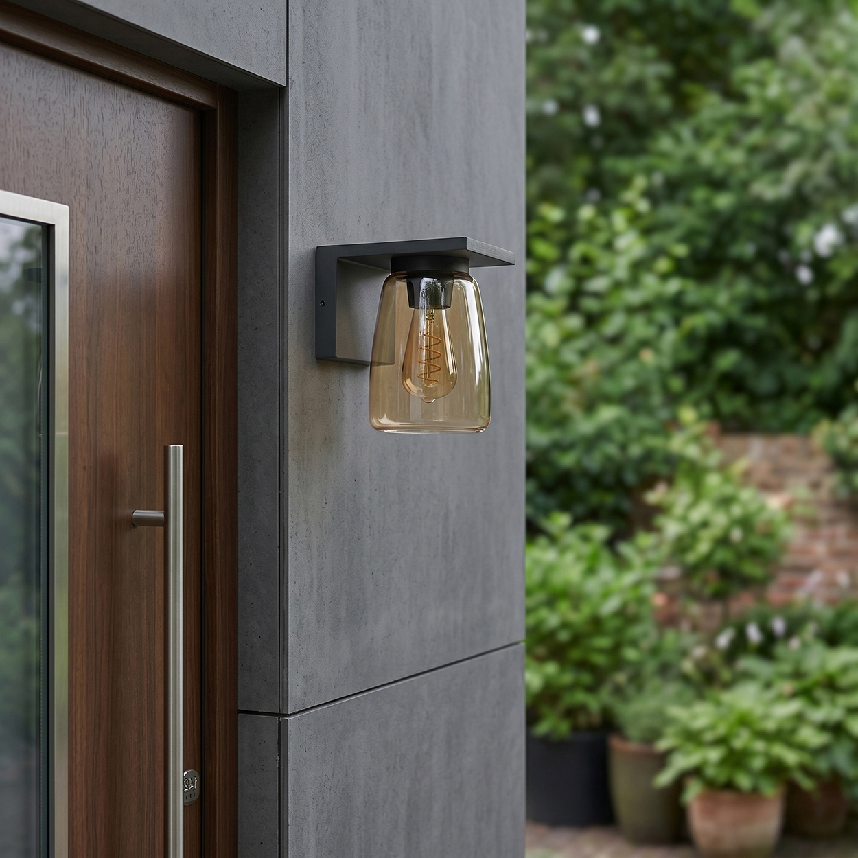 Eine Auenwandleuchte mit bernsteinfarbenem Glas und Glöhlampe an einer grauen Wand.