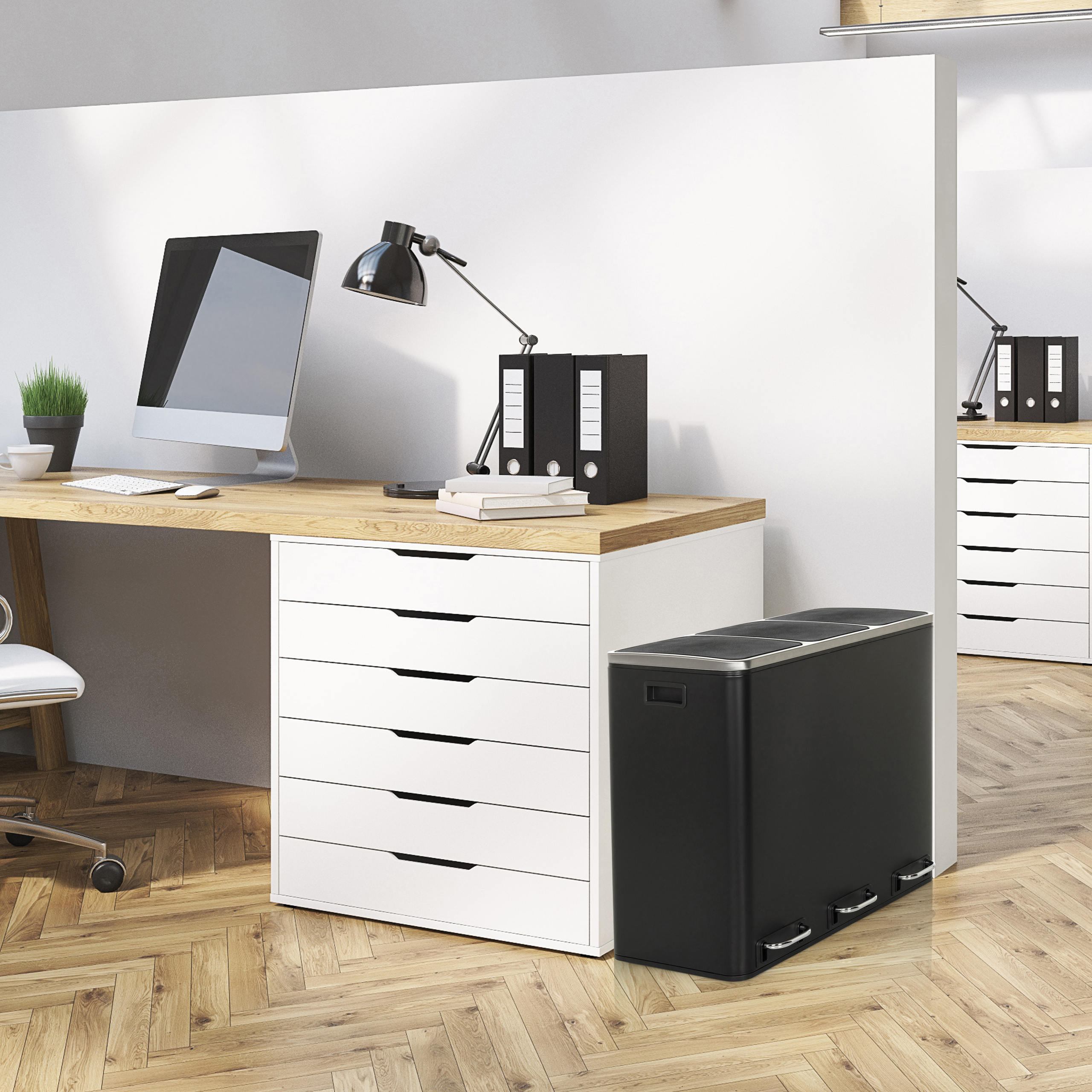 Ein Büroraum mit einem Schreibtisch, Computerausrüstung und einem Mülleimer.