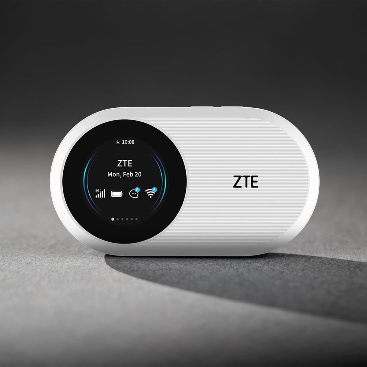 Biały router Wi-Fi ZTE wyświetlający godzinę i datę na czarnym ekranie.