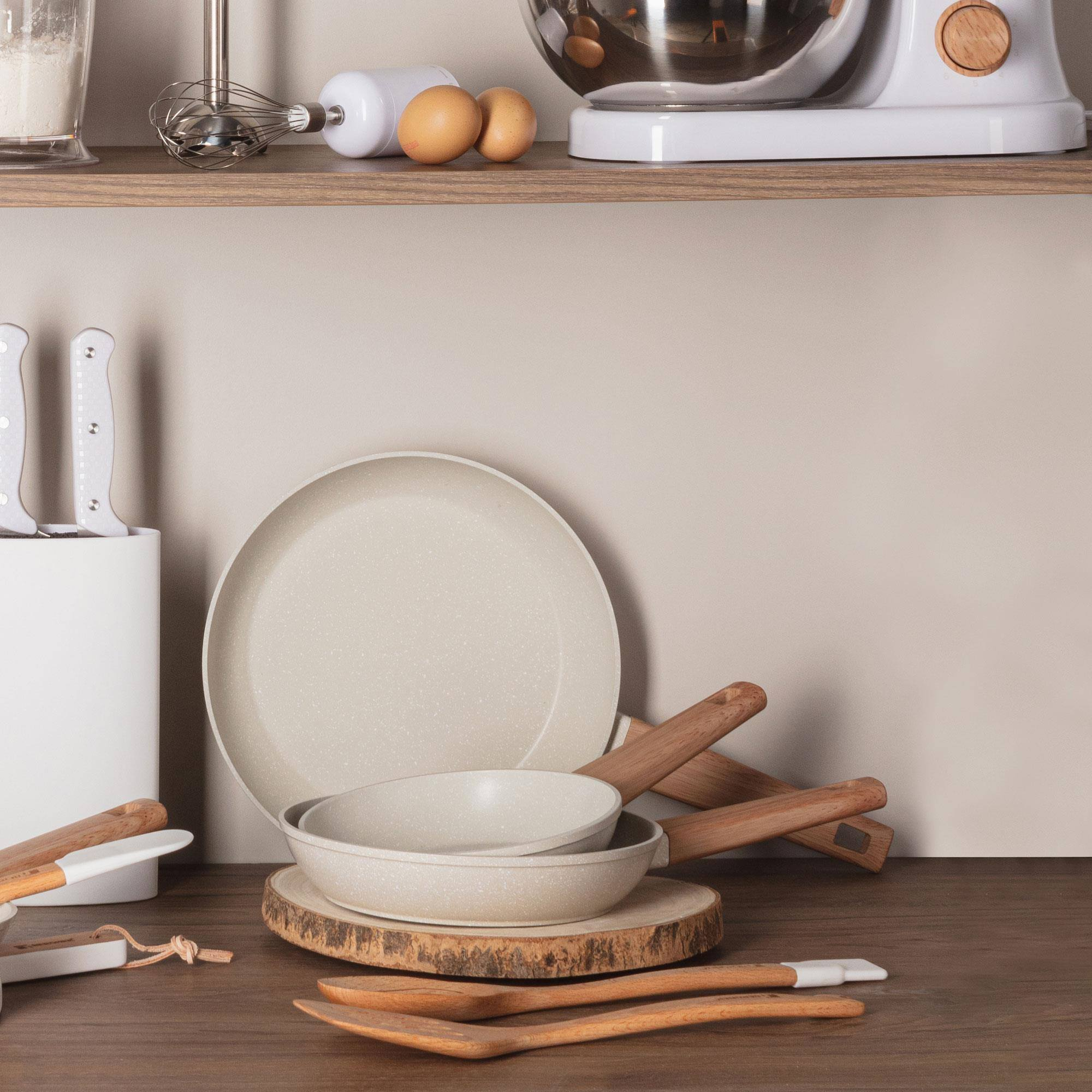 Utensilios de cocina: sartenes, bloque de cuchillos, cucharas de madera y batidora.