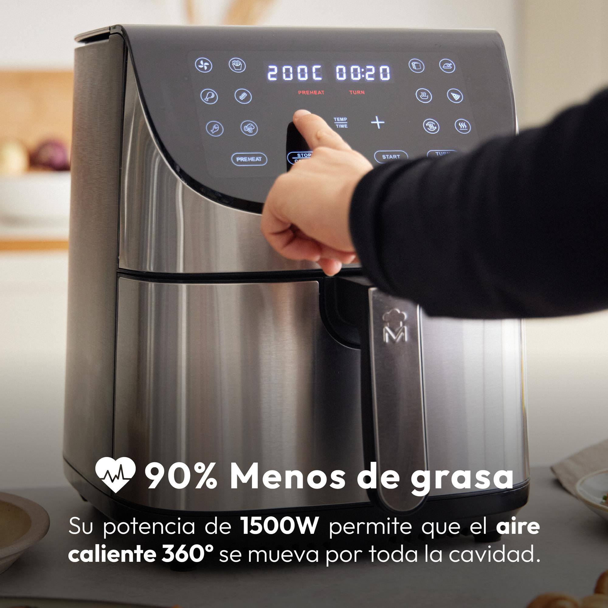 Un air fryer plateado con pantalla digital, que una mano está operando.