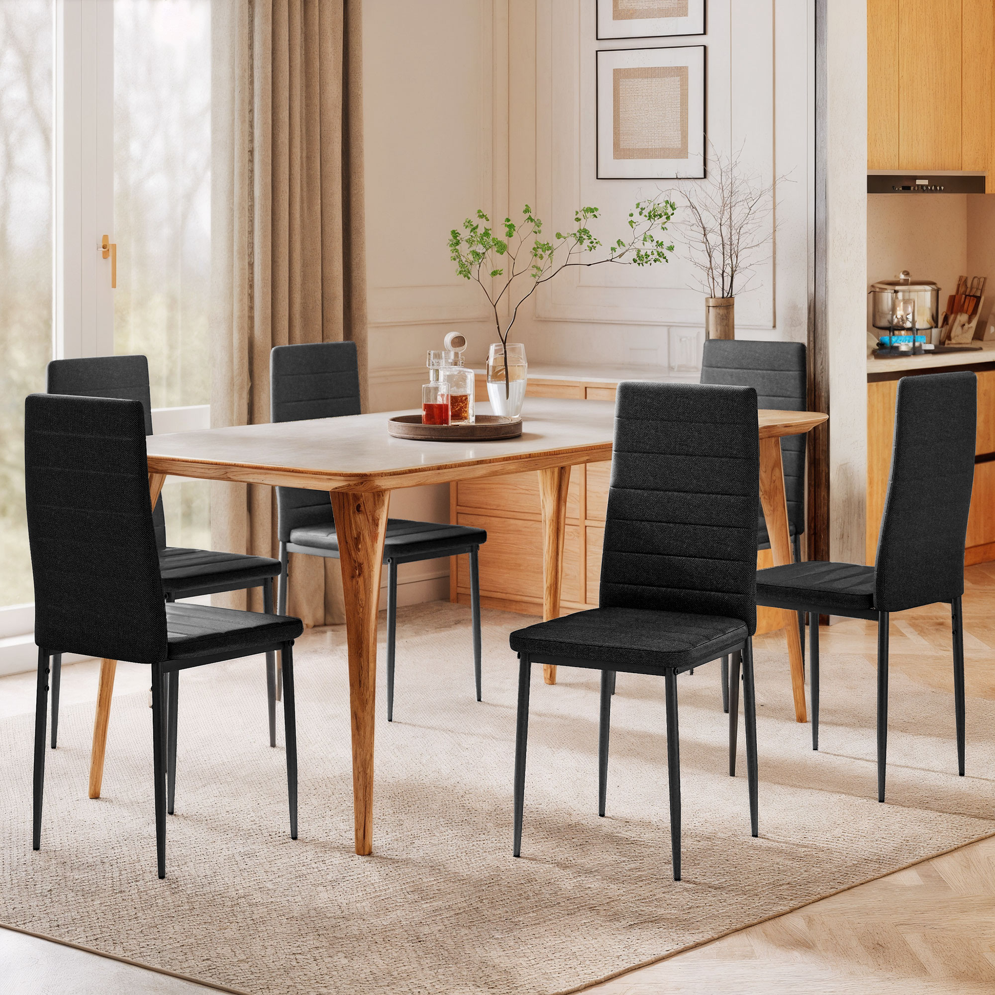 Un comedor con mesa de madera, seis sillas negras y una encimera de cocina.