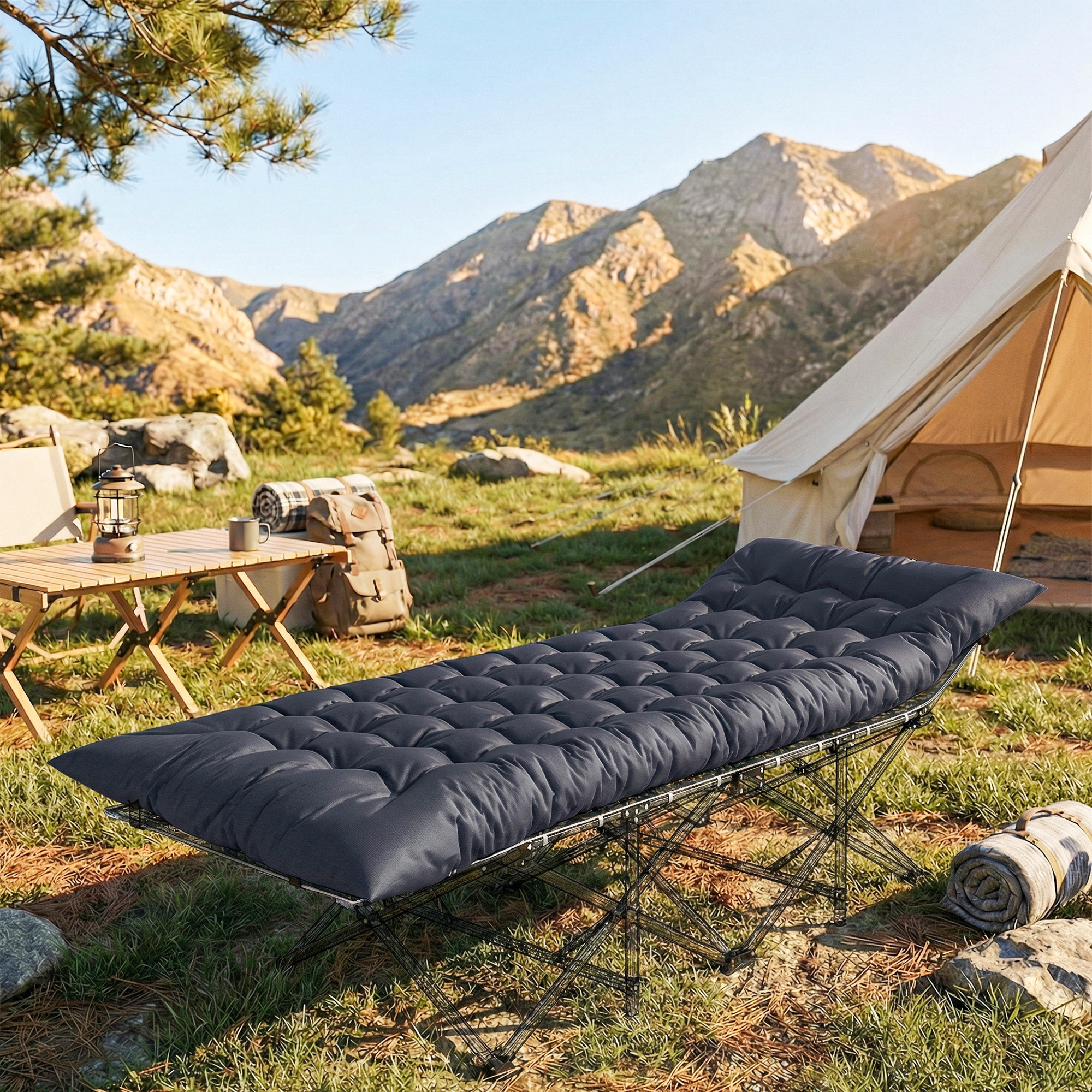 Una cama de camping gris oscuro con colchón se encuentra al aire libre cerca de una tienda y montañas.