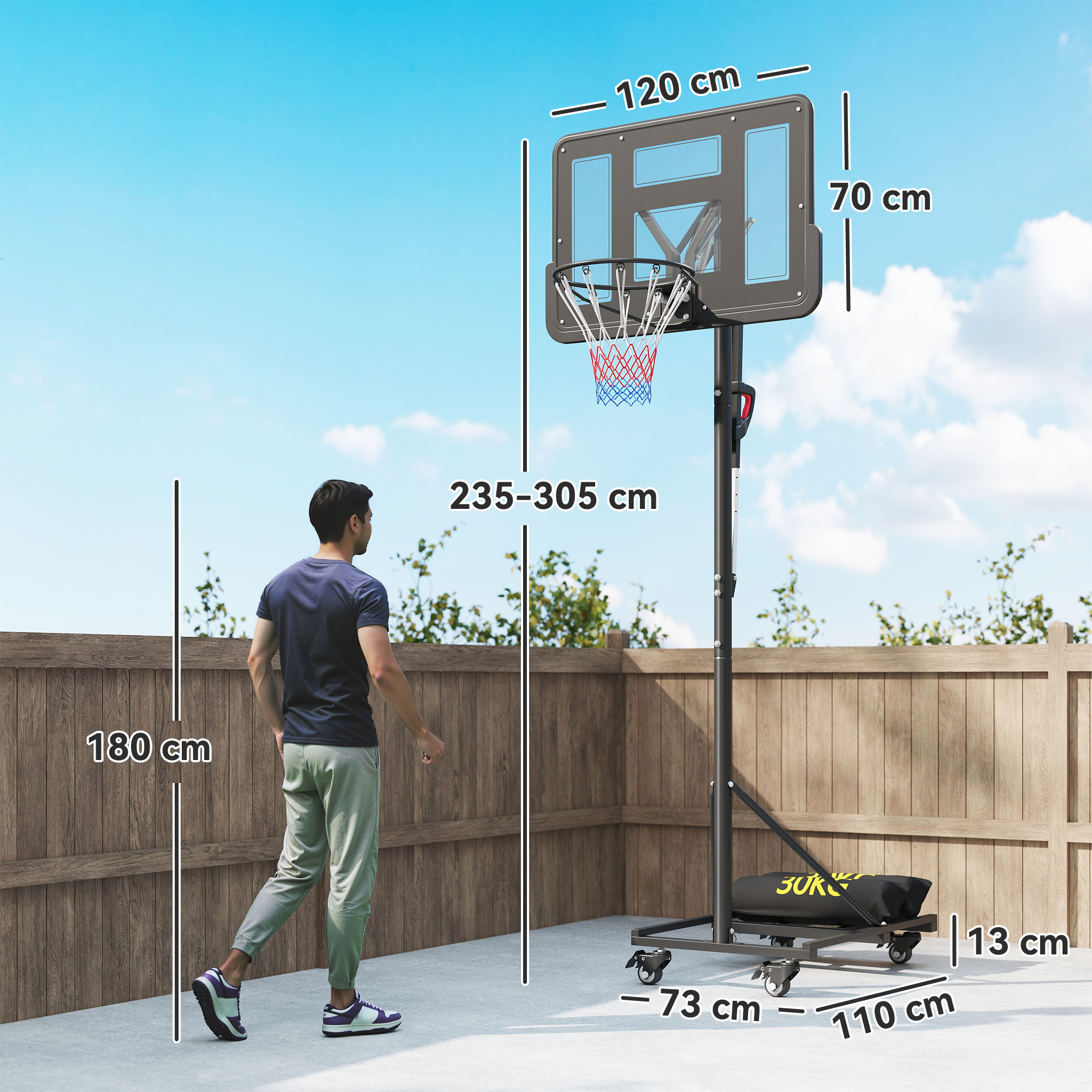 Un hombre delante de una canasta de baloncesto ajustable en altura con ruedas.