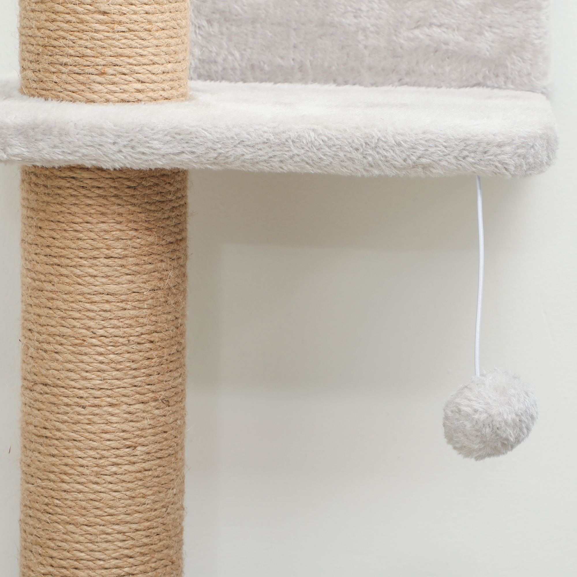 Un árbol para gatos con postes envueltos en cuerda de sisal y una plataforma.