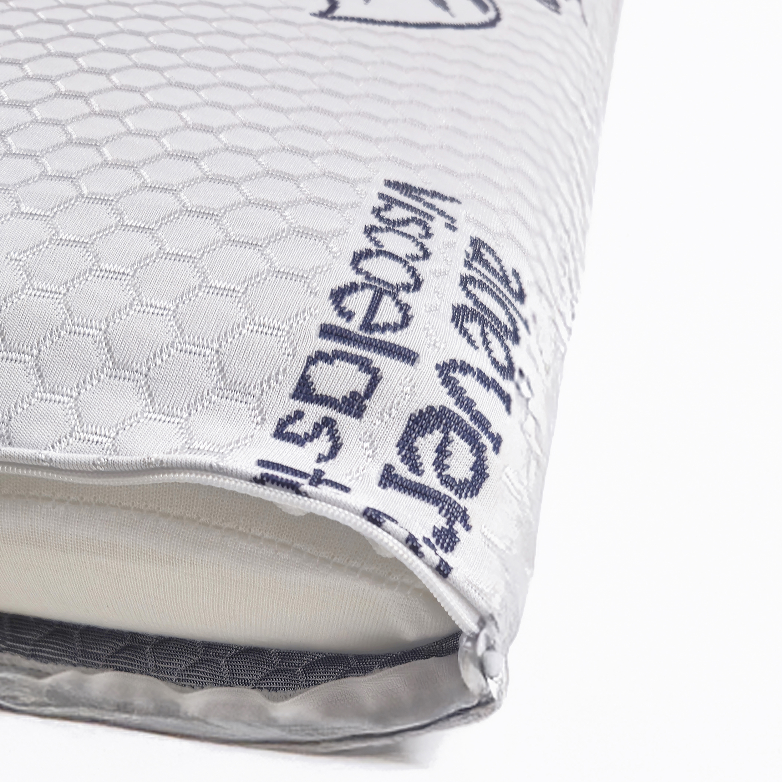 Una almohada blanca con cremallera y patrón hexagonal.