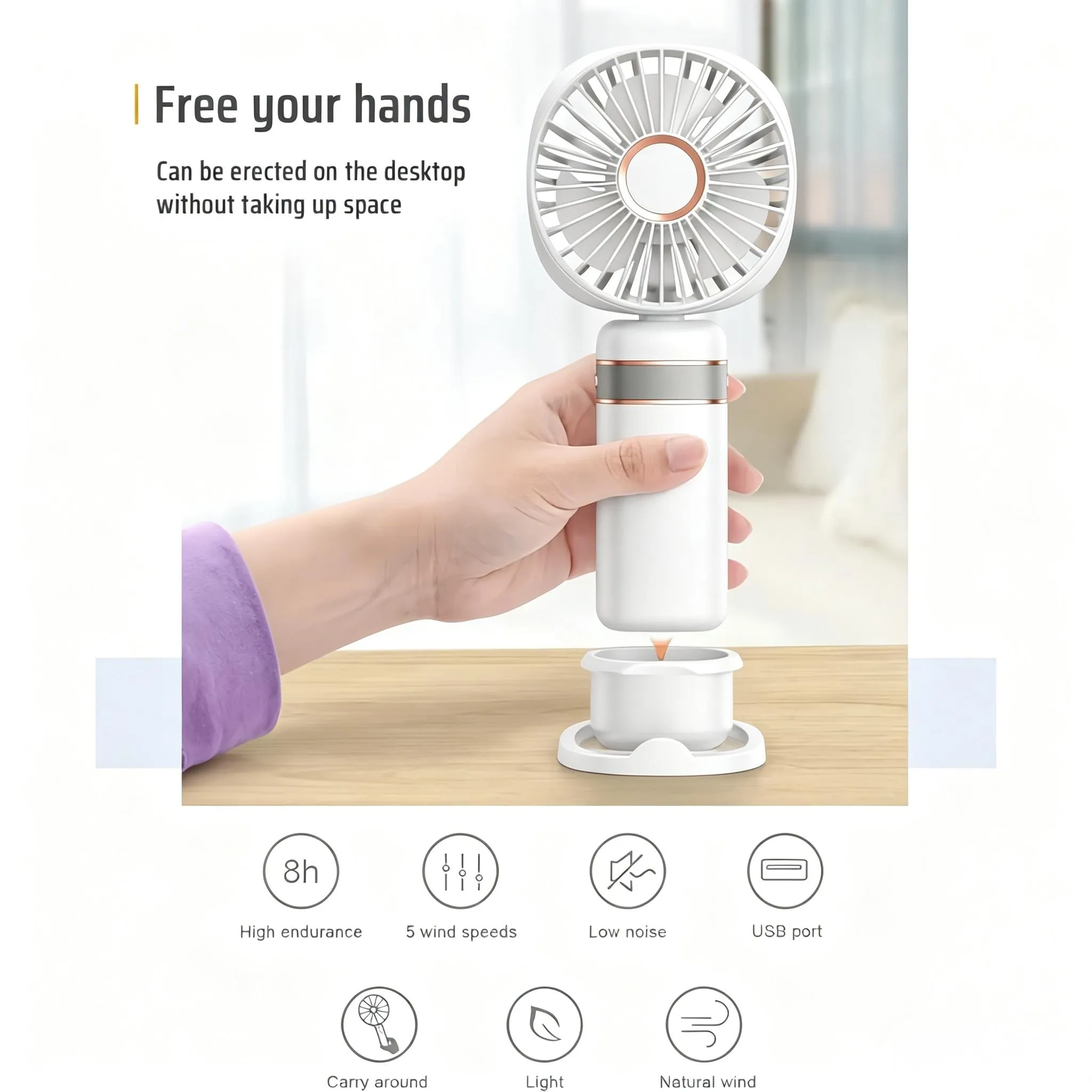 Eine weiße Hand hält einen weißen Ventilator mit Roségold-Akzenten, der auf einem Sockel steht.