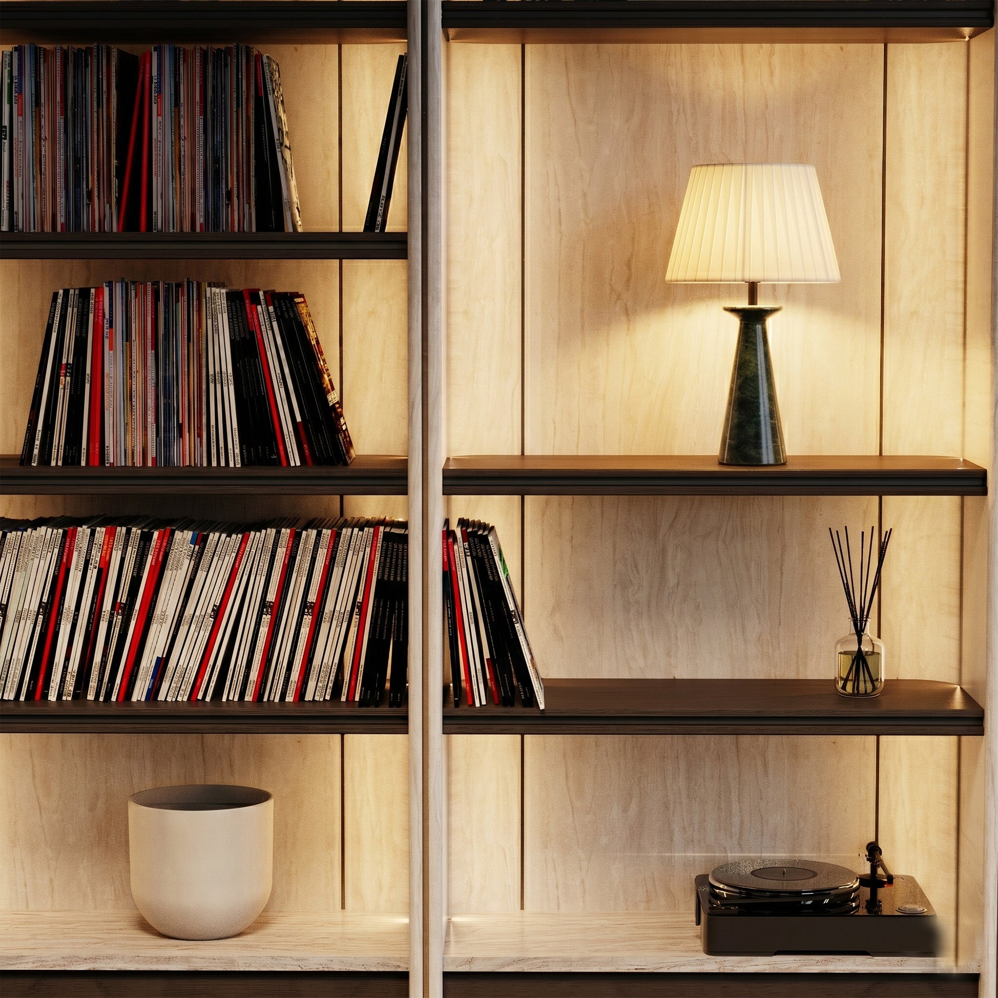 Ein Regal mit Büchern und einer Lampe, ein Plattenspieler und ein Diffusor.