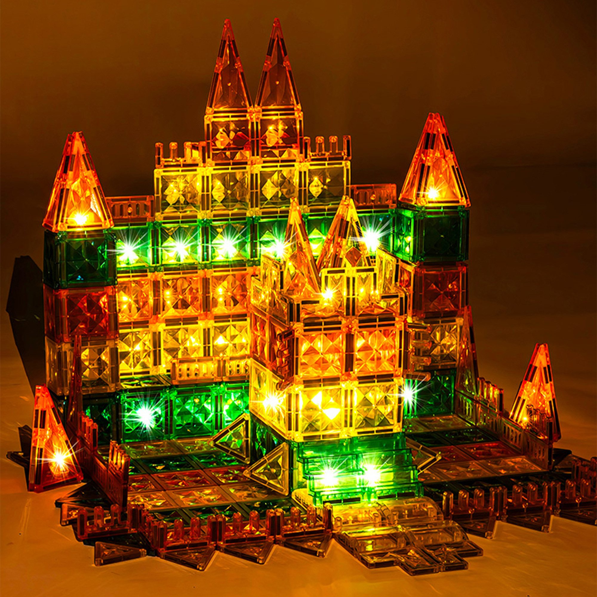 Ein beleuchtetes Magnetbauspielzeug in Form einer Burg mit Türmen und Lichtern.