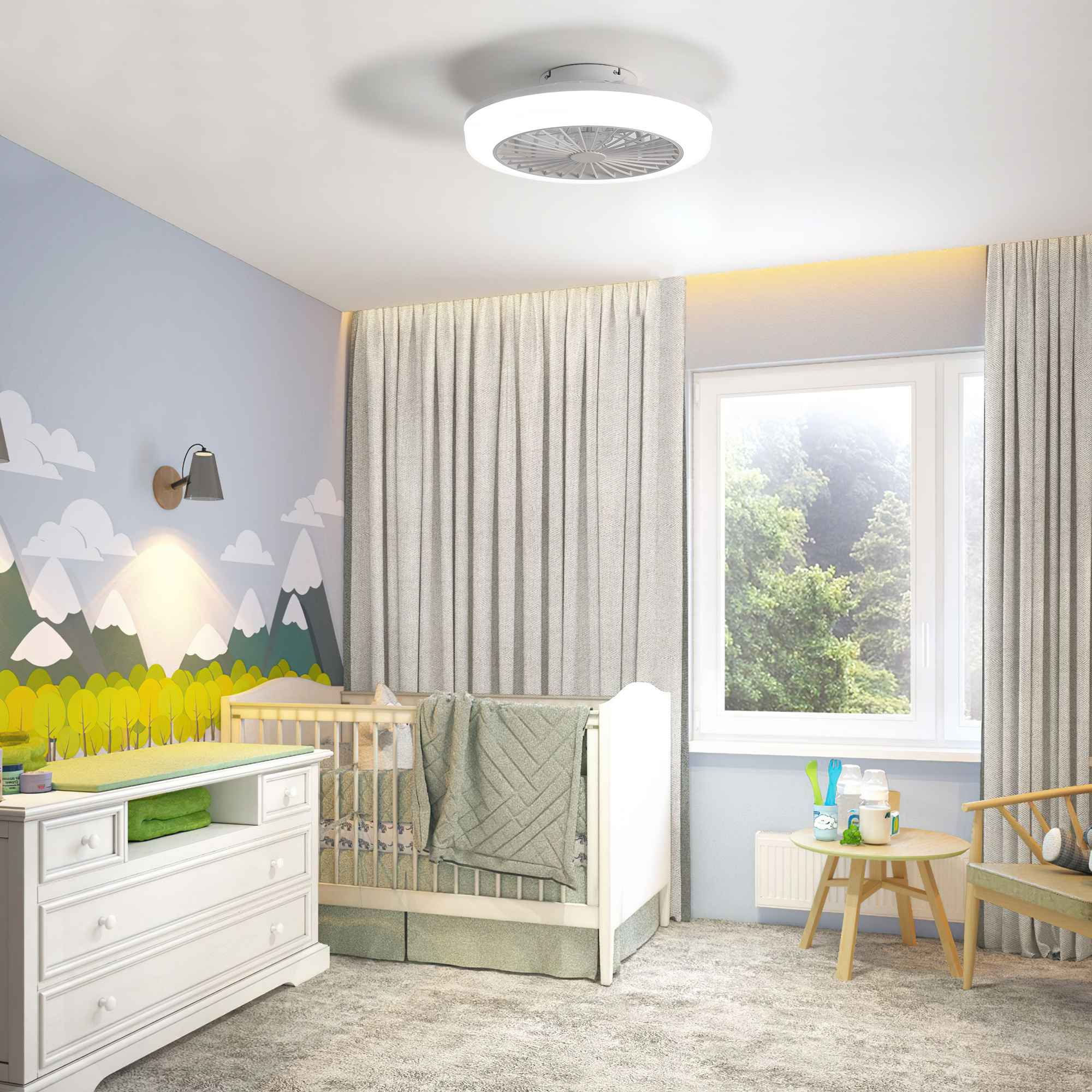 Ein Kinderzimmer mit Kinderbett, Wickeltisch und Bergmotiv. Licht ist an.