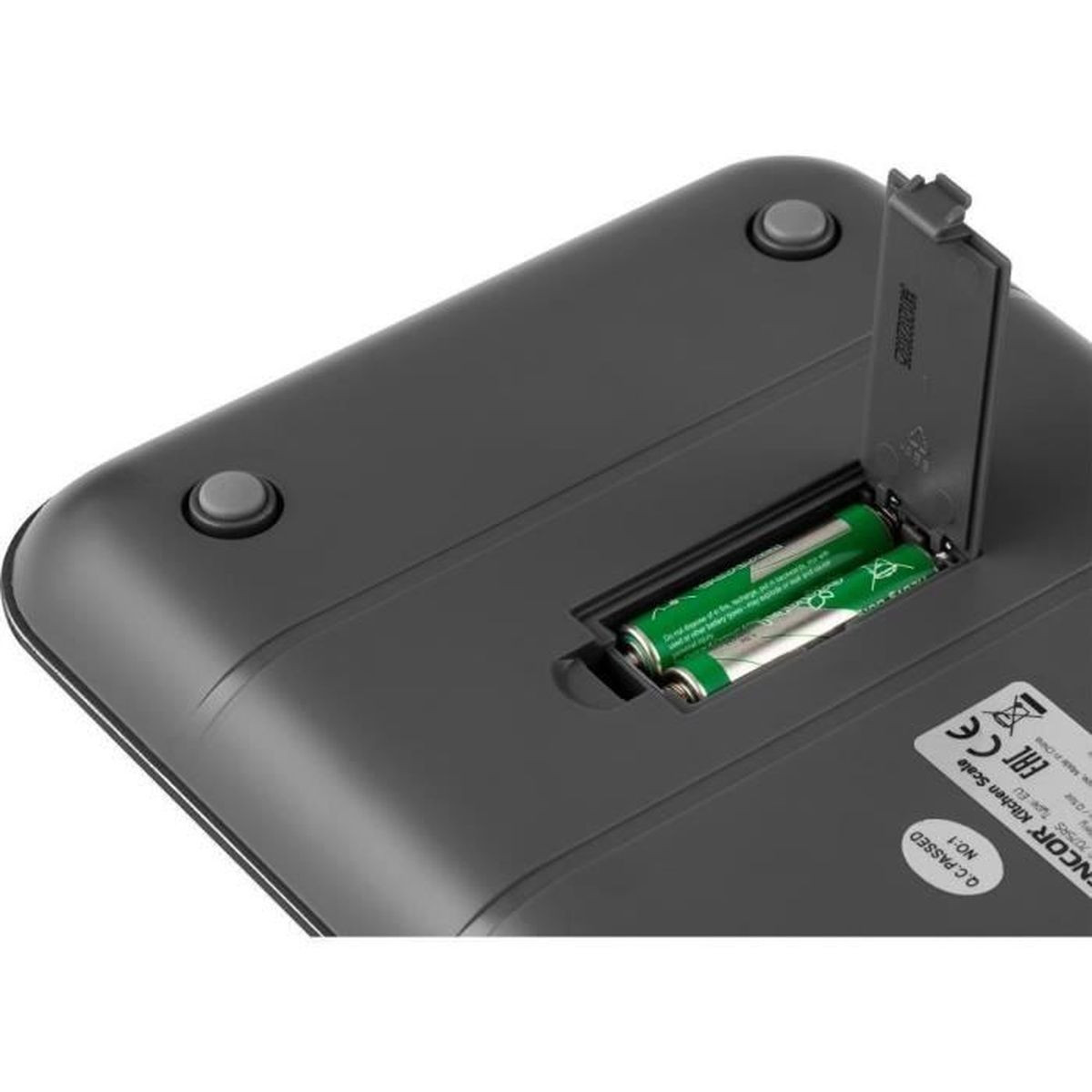 Nahaufnahme der Rückseite einer dunklen digitalen Küchenwaage mit geöffnetem Batteriefach und zwei AA-Batterien.