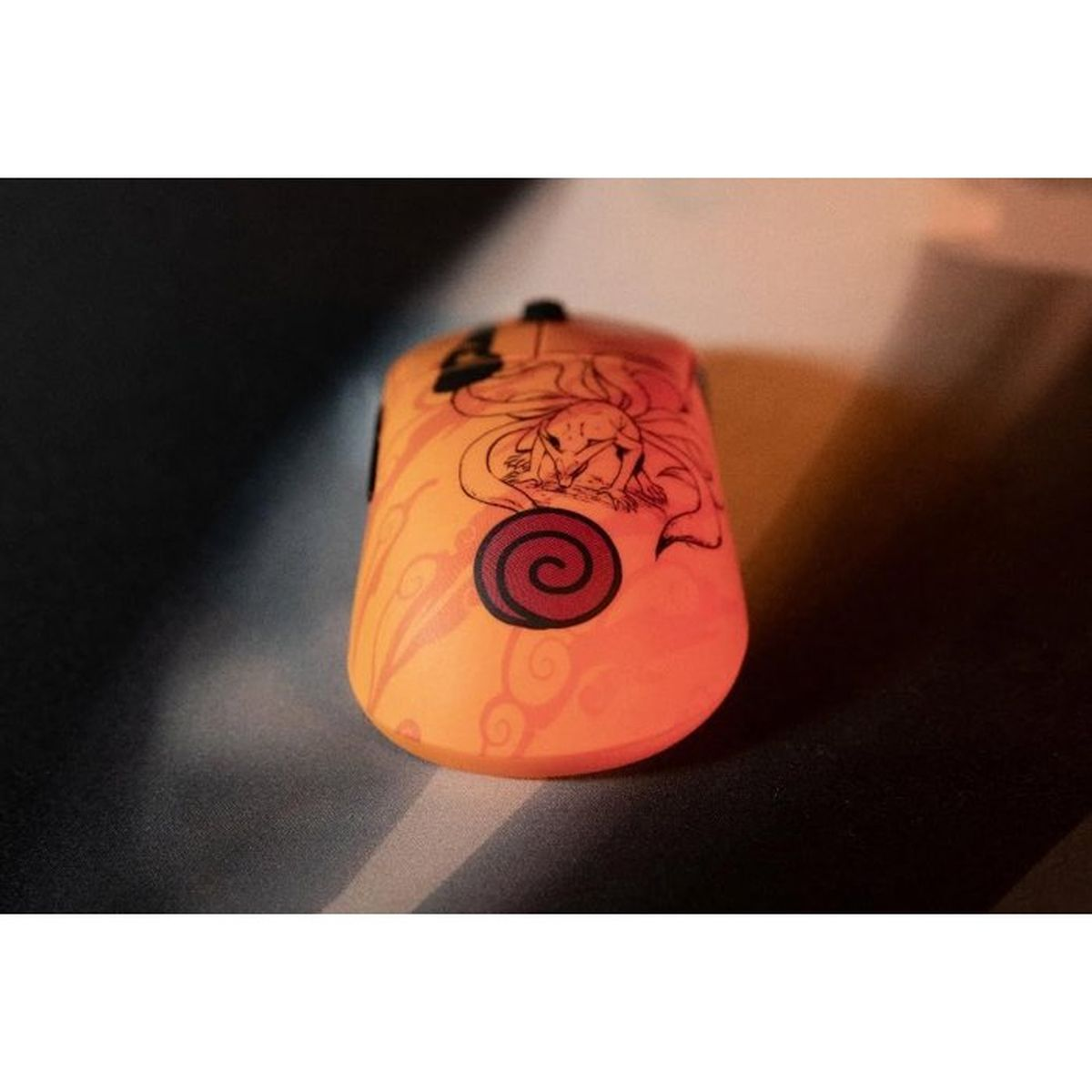 Orange Maus mit schwarzem Naruto-Fuchs-Design und Wirbel-Emblem auf dunklem Hintergrund.