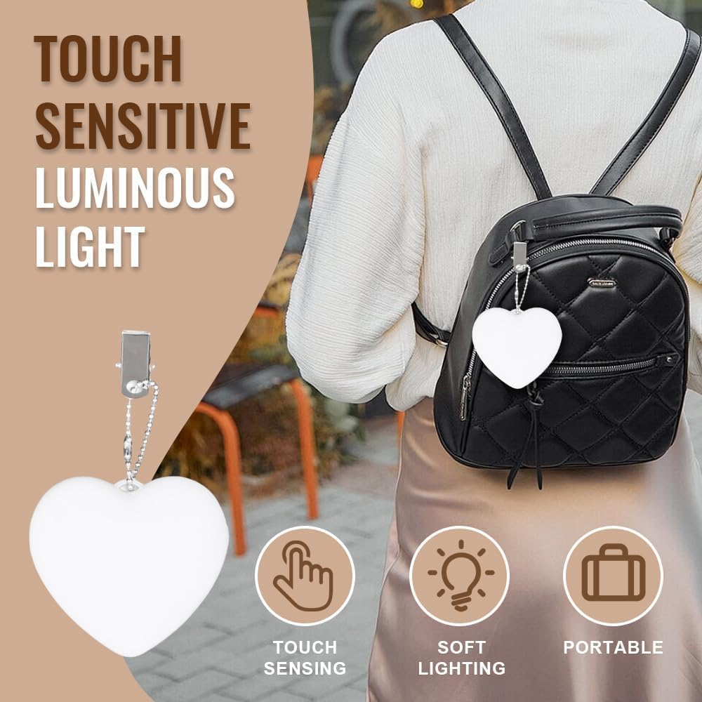 Ein weißes Herzlicht hängt an einem schwarzen Rucksack. Text: Touch Sensitive Luminous Light.