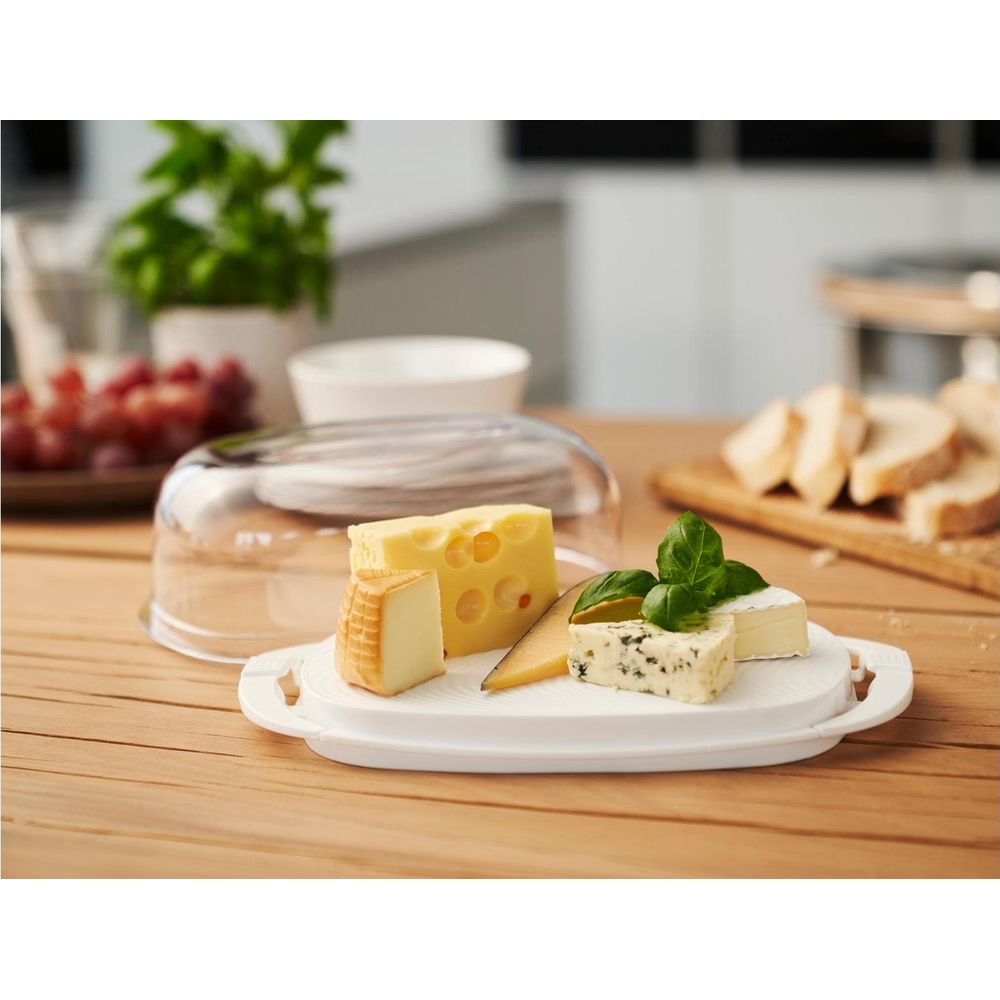 Assortimento di formaggi con pane e uva su un tavolo di legno.
