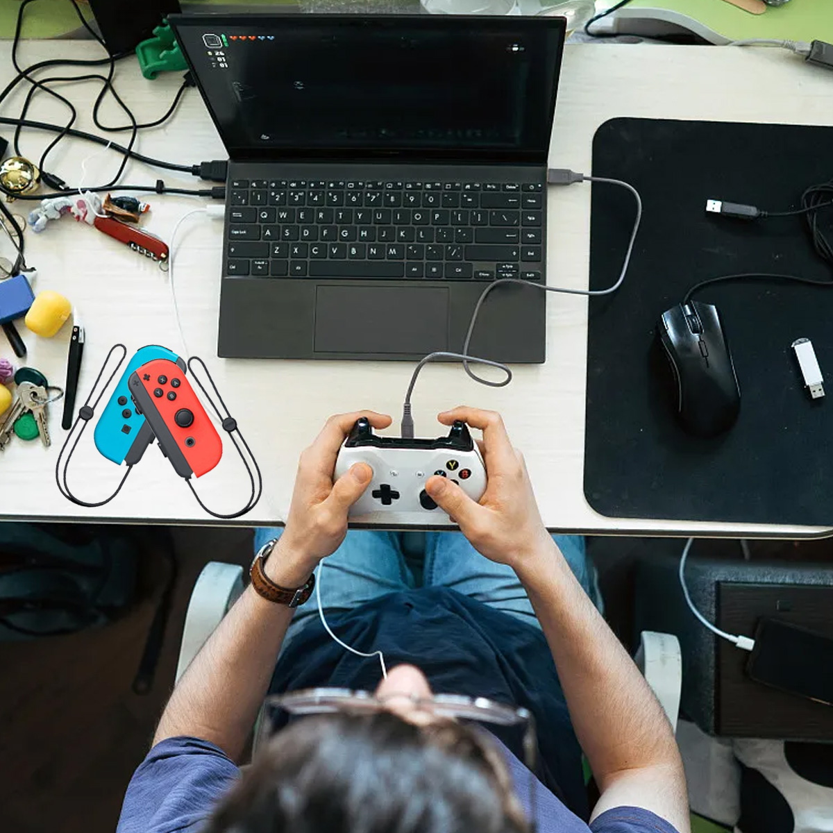 Person spielt Videospiel mit Controller, Laptop und Maus auf dem Tisch.