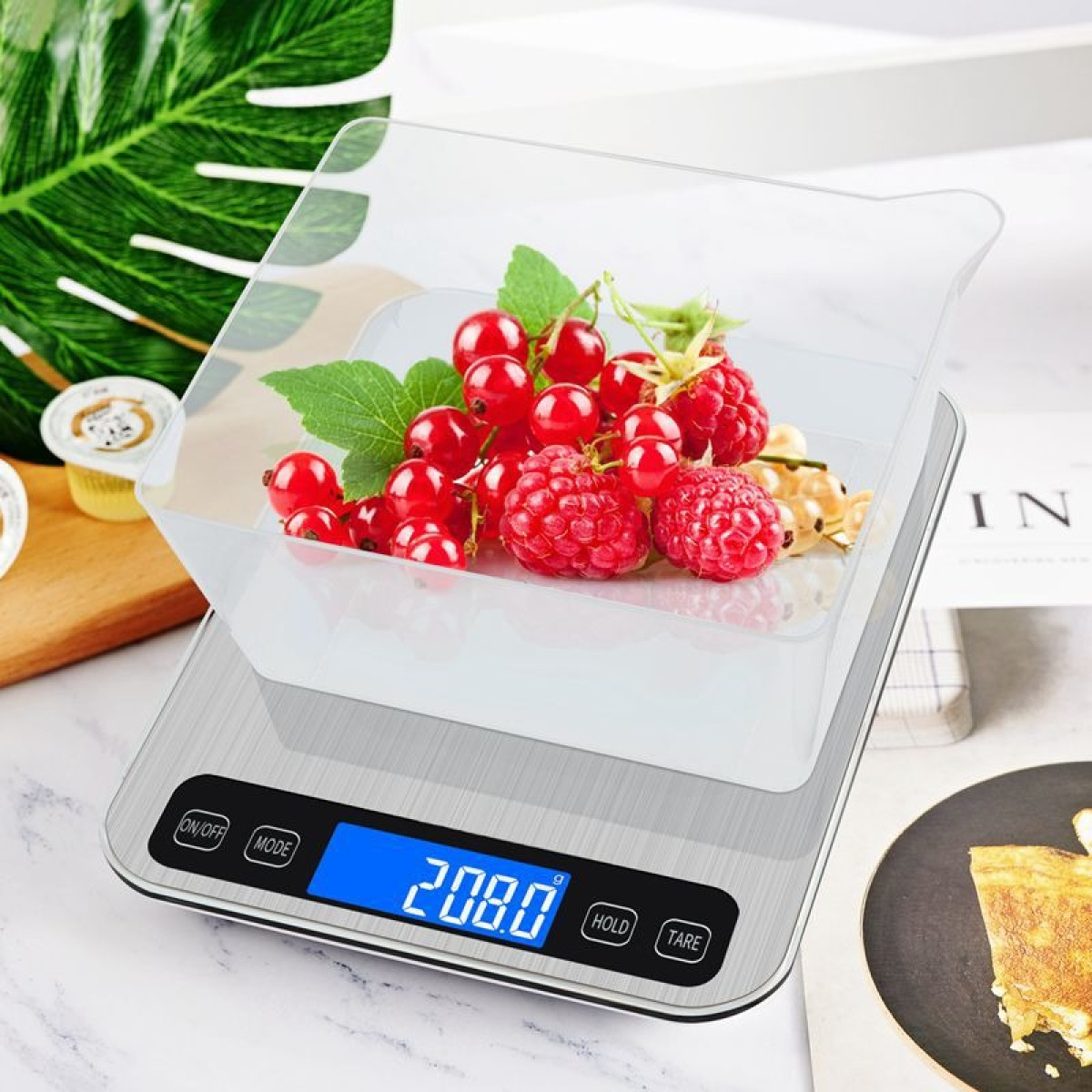 Eine digitale Küchenwaage mit Beeren. Anzeige zeigt 208.0g.