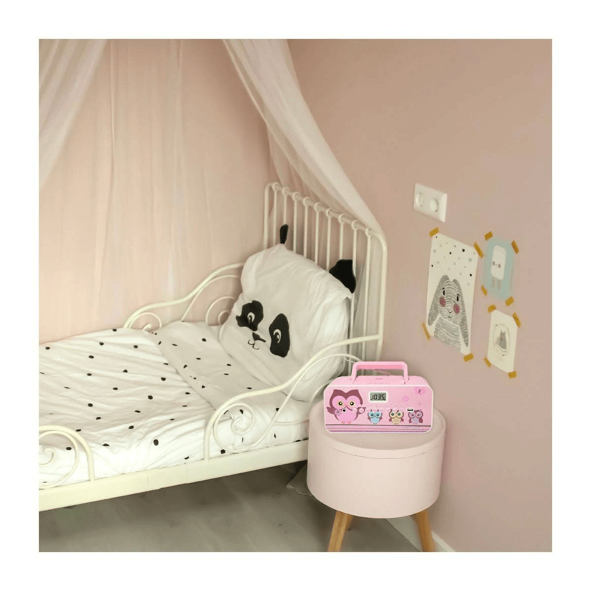 Chambre d'enfant avec lit, coussin panda, couette et table de nuit rose avec réveil.
