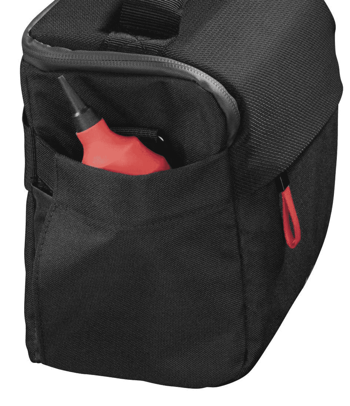 Ein roter Blasebalg steckt in der Außentasche einer schwarzen Tasche.