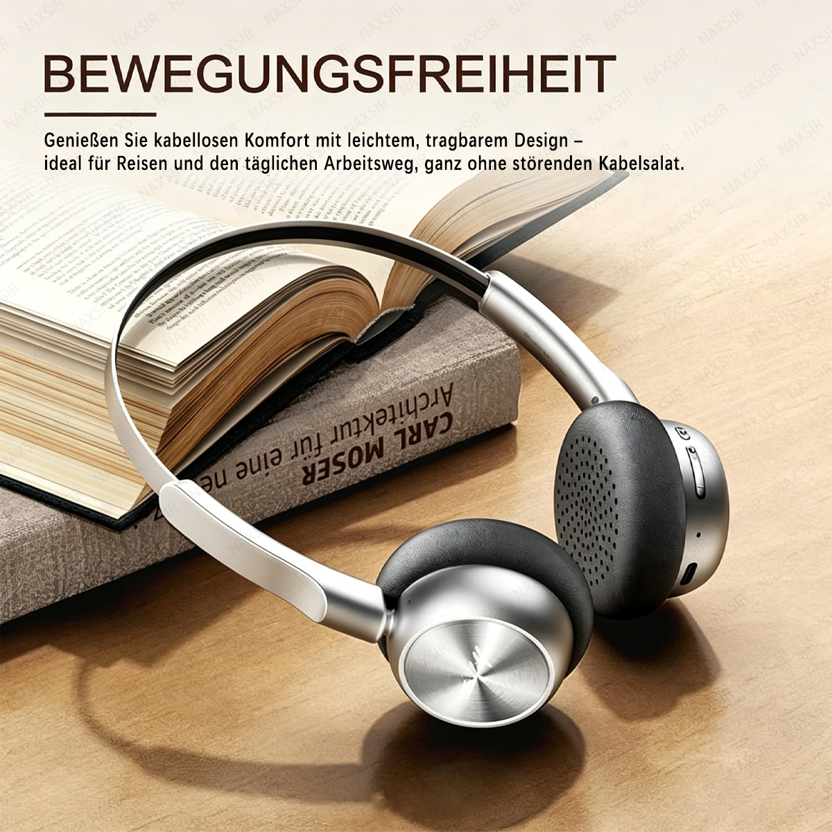 Silberne Kopfhörer liegen auf einem Buch. Text auf Deutsch.