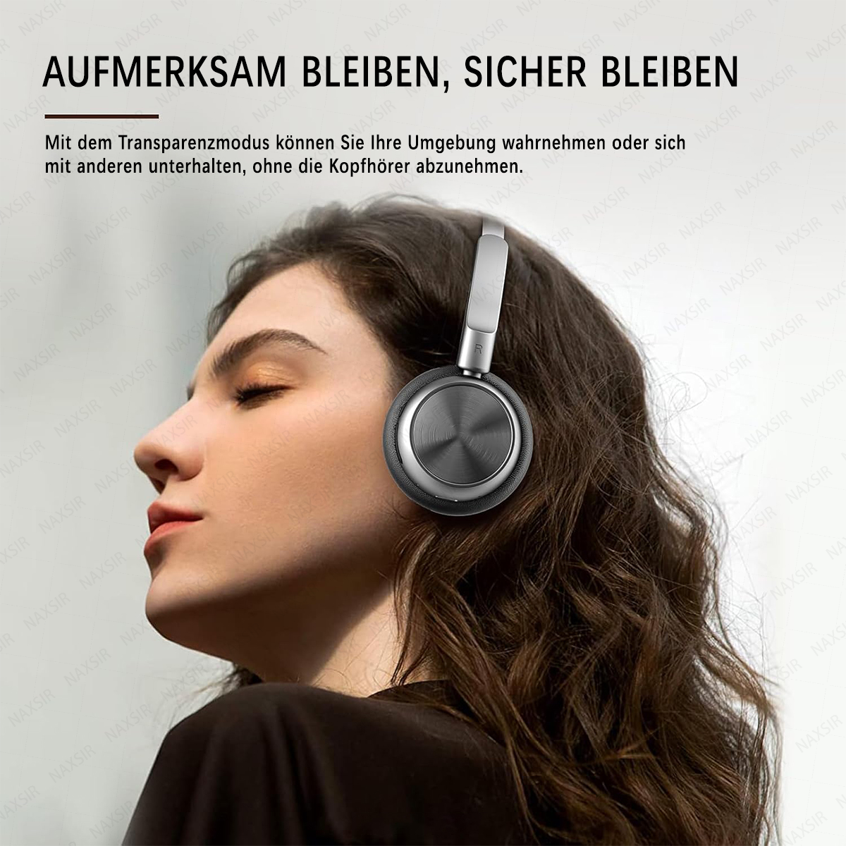 Eine Frau mit geschlossenen Augen trägt Kopfhörer. Graue Kopfhörer mit silbernem Bügel.