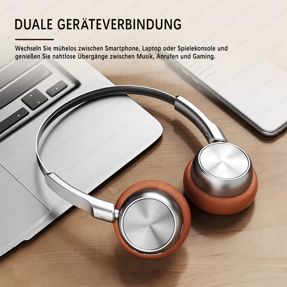 Silberne und braune Kopfhörer liegen auf einer Tastatur und einem Handy.