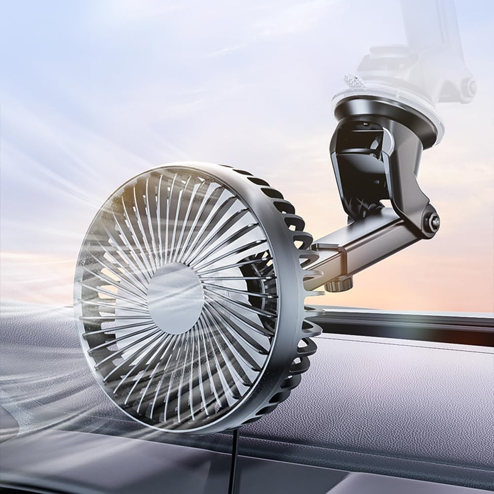 Ein kleiner, grauer Ventilator mit Saugnapfhalterung sitzt auf einem Armaturenbrett.