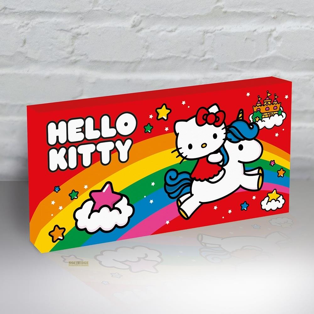 Hello Kitty reitet auf einem Einhorn über einen Regenbogen, Sterne und Wolken. Eine Burg ist am Himmel.