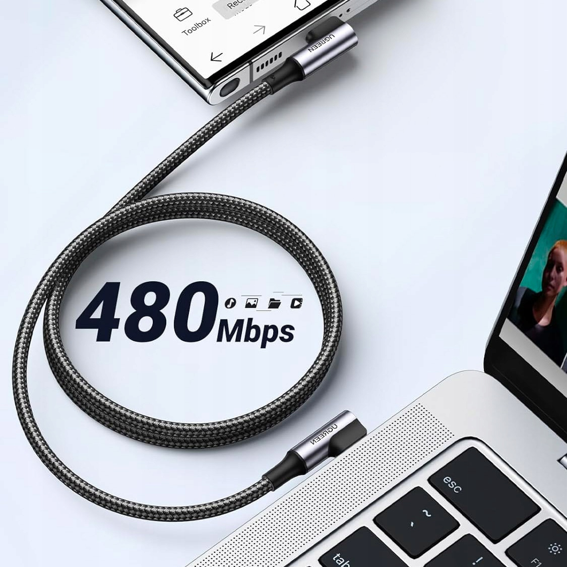Cavo USB-C grigio collega smartphone a laptop. 480 Mbps.