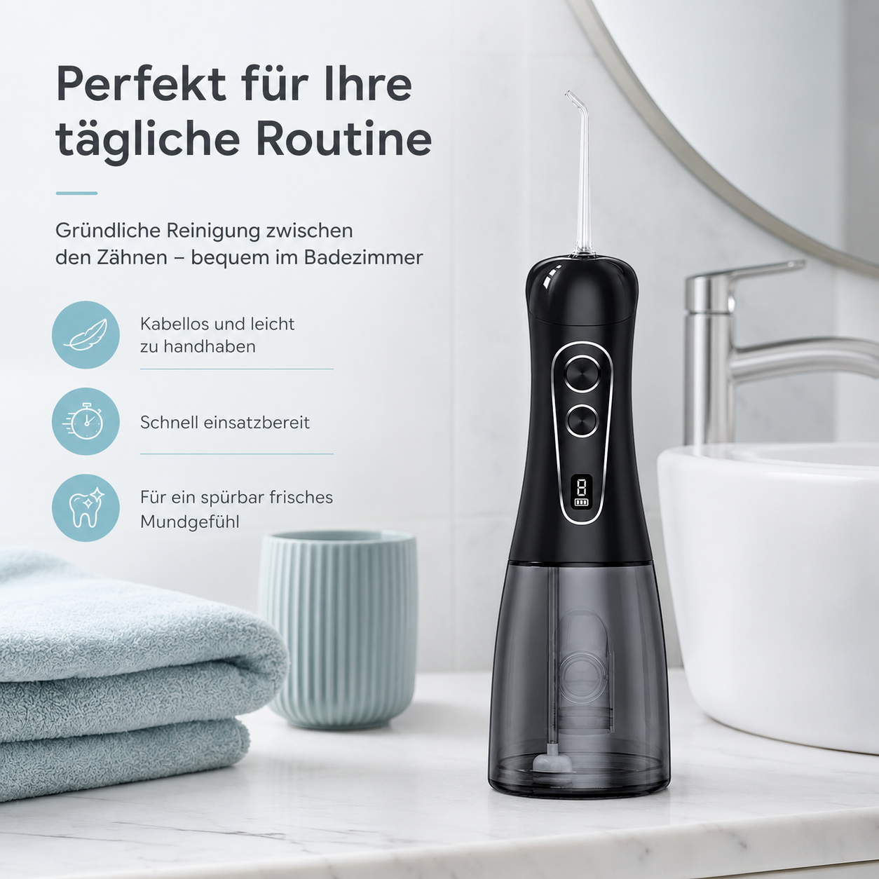 Schwarzer kabelloser Mundduschen im Badezimmer neben Handtüchern und Becher.