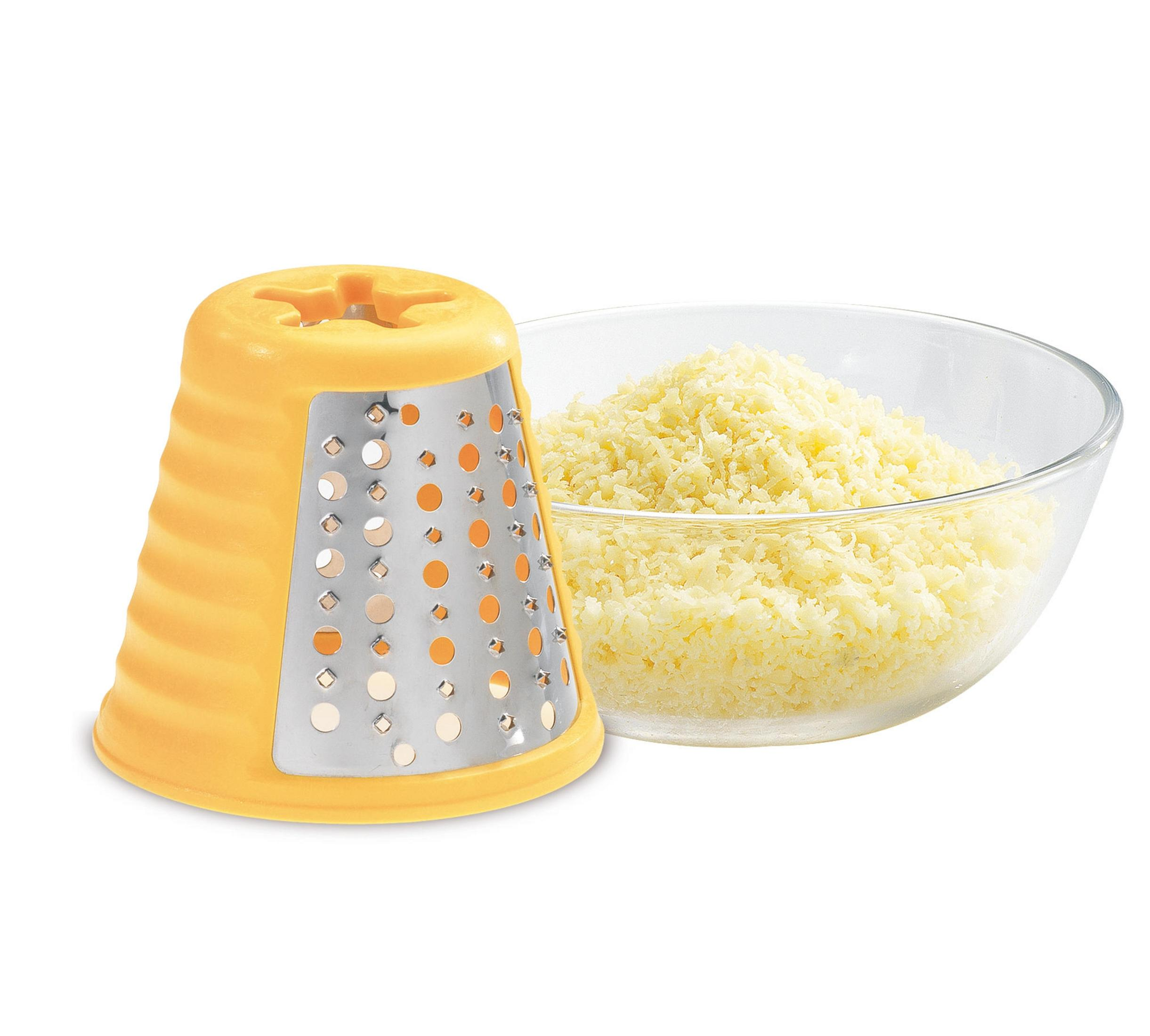 Una grattugia gialla è accanto a una ciotola di vetro piena di formaggio grattugiato.