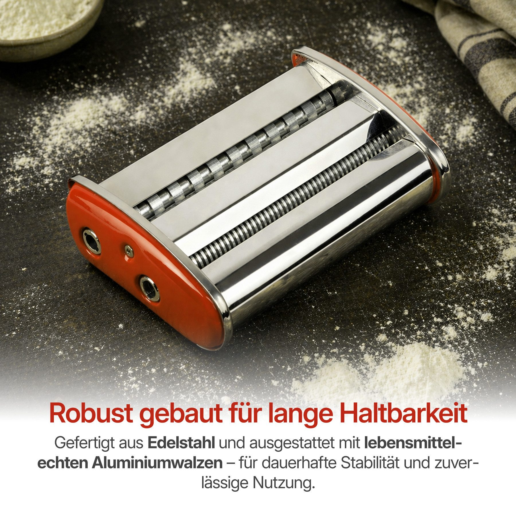 Eine Nudelmaschine aus Edelstahl mit roten Akzenten liegt auf dunklem Untergrund.