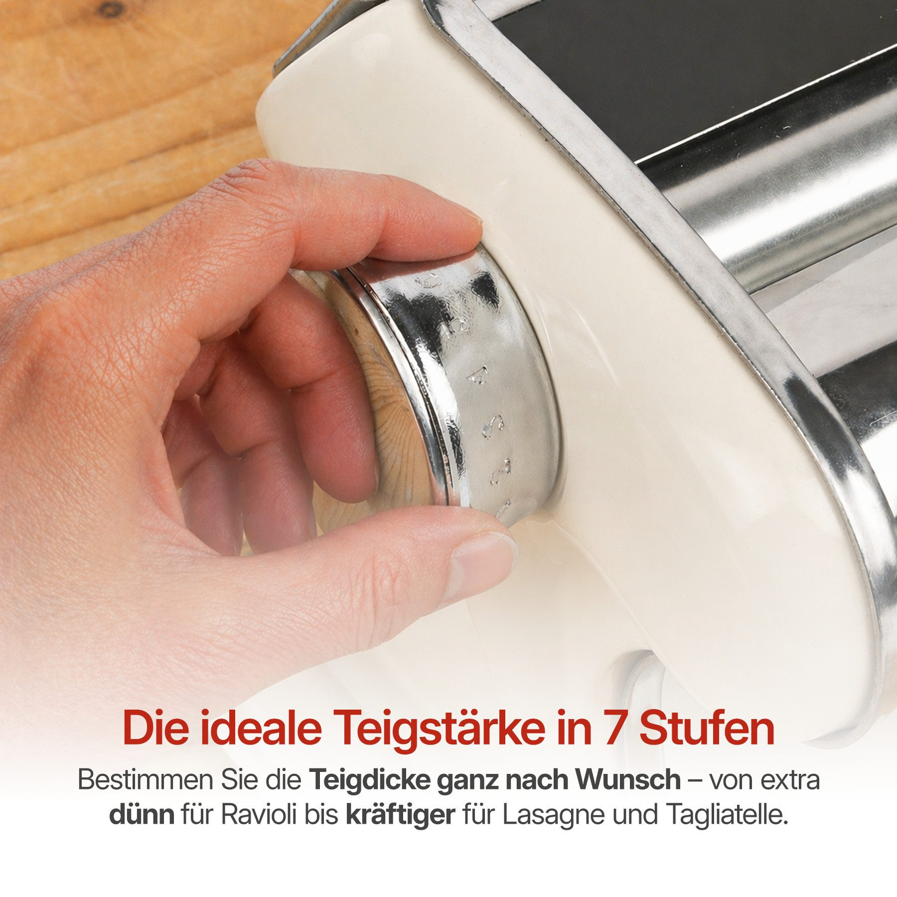 Eine Hand dreht den Knopf einer Nudelmaschine, um die Teigdicke einzustellen.
