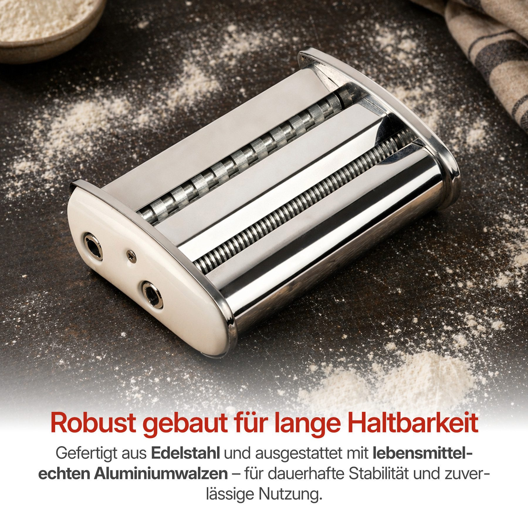 Edelstahl-Nudelmaschine mit Walzen auf dunklem Holztisch mit Mehl.