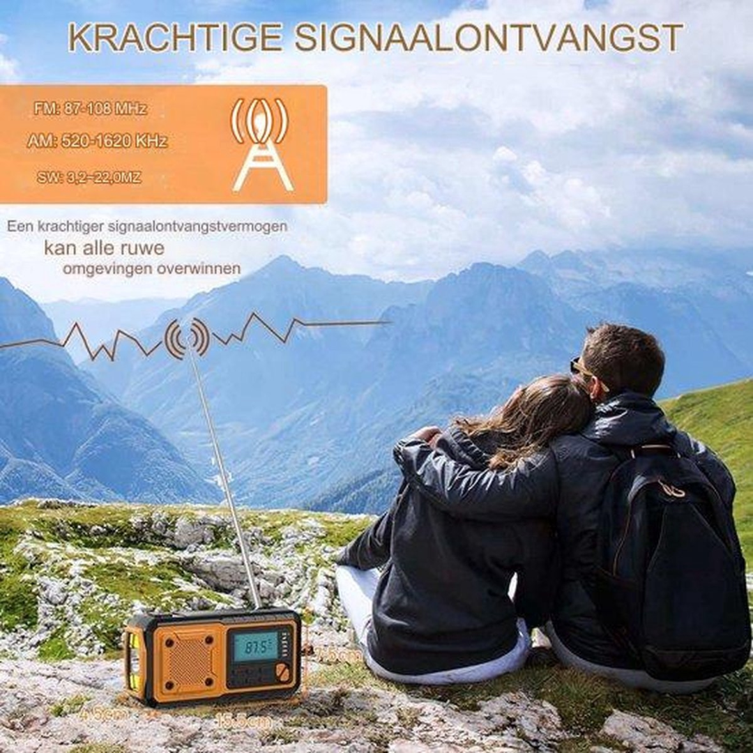 A couple sits on a mountain overlooking scenery, with a radio beside them.