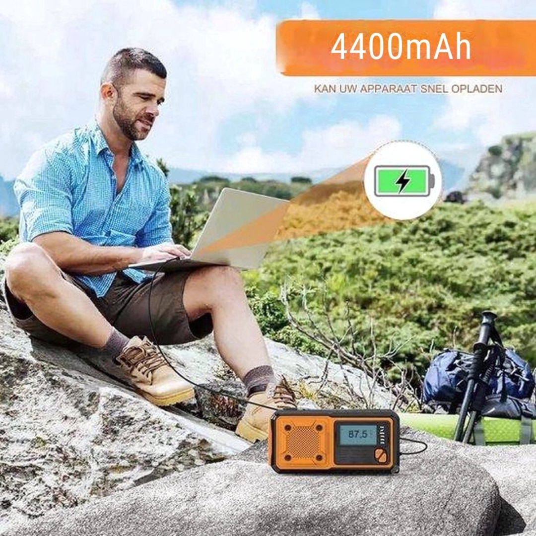 Man with laptop and power bank in mountainous landscape.