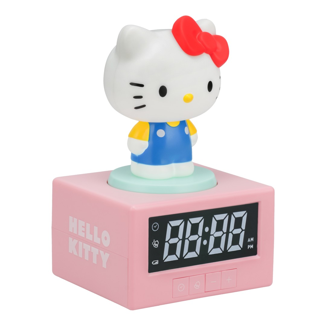 Różowy budzik z figurką Hello Kitty i cyfrowym wyświetlaczem.